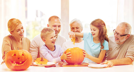 Image showing happy family sitting with pumpkins at home