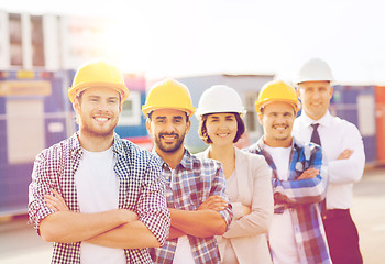 Image showing group of smiling builders in hardhats outdoors