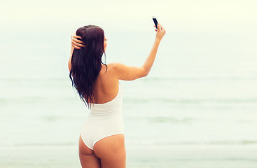 Image showing young woman taking selfie with smartphone