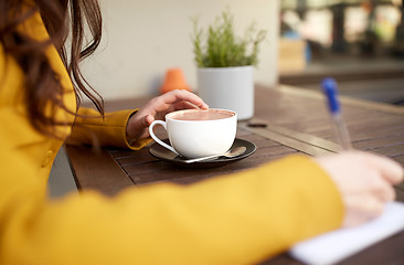 Image showing close up of woman drinking cocoa at cafe