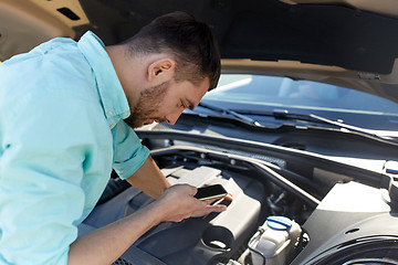 Image showing man with smartphone and broken car at countryside