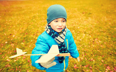 Image showing happy little boy playing with toy plane outdoors