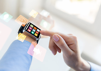 Image showing close up of hands setting smart watch with icons