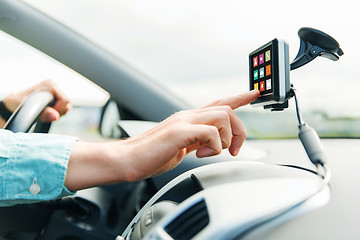 Image showing close up of man with icons on gadget driving car