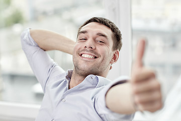 Image showing smiling man showing thumbs up at home or office