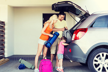 Image showing happy family packing things to car at home parking