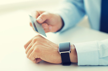 Image showing close up of hands with smart watch and credit card