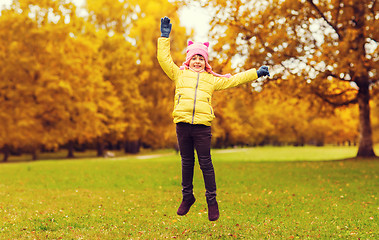 Image showing happy little girl jumping outdoors