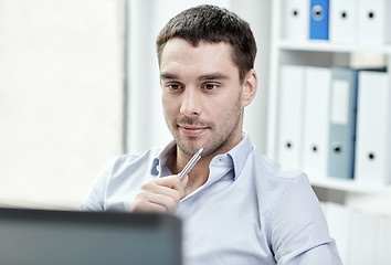 Image showing young businessman with laptop computer at office