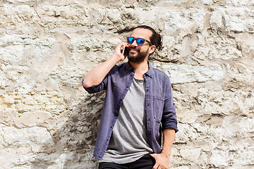 Image showing smiling man with smartphone calling on city street