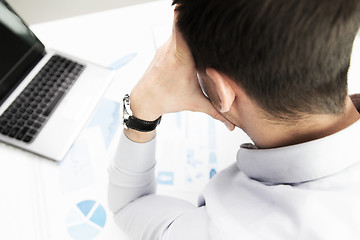 Image showing close up of businessman with laptop and papers