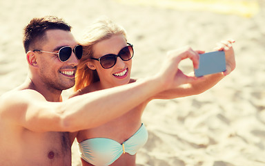 Image showing happy couple in swimwear walking on summer beach