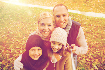 Image showing happy family with selfie stick in autumn park