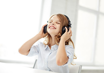 Image showing smiling little girl with headphones at home