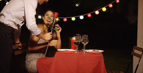 Image showing Man surprises his beautiful date with single rose