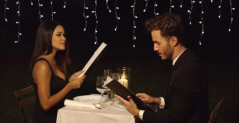 Image showing Young romantic couple reading the menu