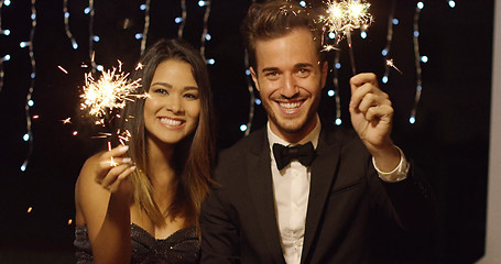 Image showing Young couple celebrating new year with sparklers