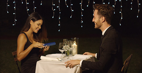 Image showing Gorgeous young woman opening a gift