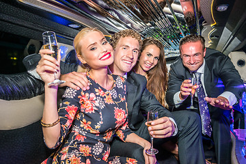 Image showing Portrait of young male and female friends with champagne flutes 