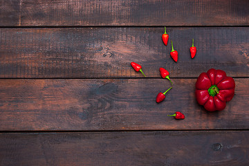 Image showing fresh bitter and sweet pepper on wooden table background