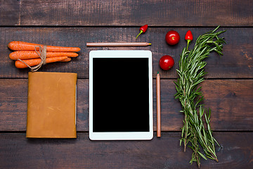 Image showing The tablet, notebook, fresh bitter and sweet pepper on wooden table background