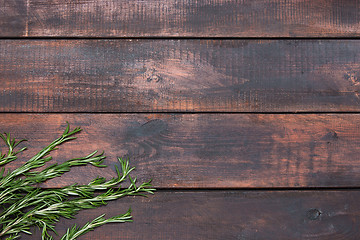 Image showing Bunch of rosemary on wooden table, rustic style, fresh organic herbs, top view