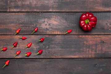 Image showing fresh bitter and sweet pepper on wooden table background