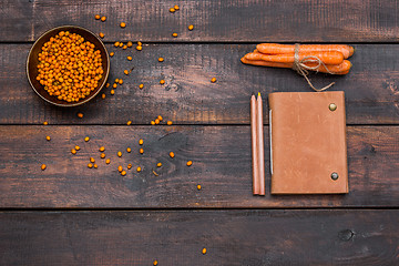 Image showing Office desk table with notebooks, fresh buckthorn berries on wooden table