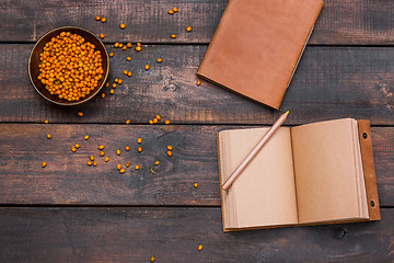 Image showing Office desk table with notebooks, fresh buckthorn berries on wooden table