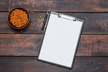 Image showing Office desk table with notebooks, fresh buckthorn berries on wooden table