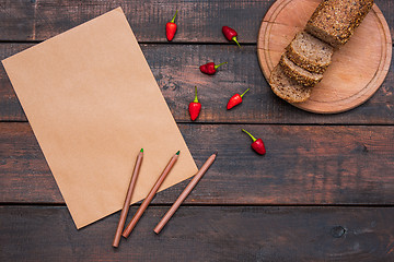 Image showing Office desk table with pencils, supplies and fresh bread