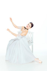 Image showing Ballerina in white dress sitting, studio background.