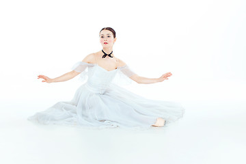 Image showing Ballerina in white dress sitting, studio background.