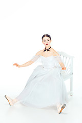 Image showing Ballerina in white dress sitting, studio background.