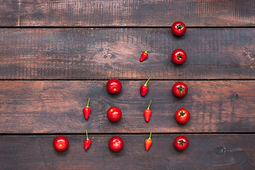 Image showing The cherry tomatoes, peppers, chilli on wooden table