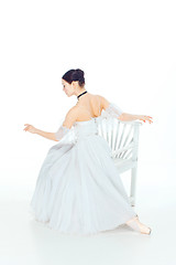 Image showing Ballerina in white dress sitting, studio background.