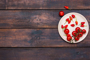 Image showing The cherry tomatoes, peppers, chilli on wooden table