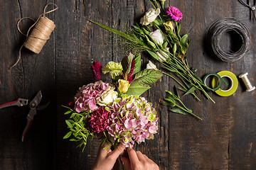 Image showing The florist desktop with working tools and ribbons