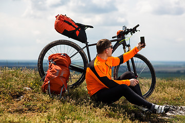 Image showing Sportive Man Stops Cycling and Has a Rest on Valley