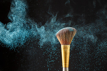 Image showing Brush with blue shadows on black background