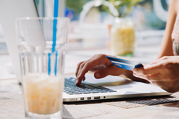 Image showing woman using laptop with credit card in hand