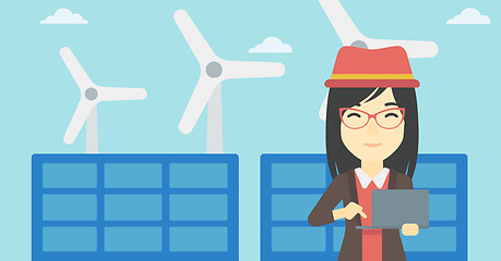 Image showing Woman checking solar panels and wind turbines.