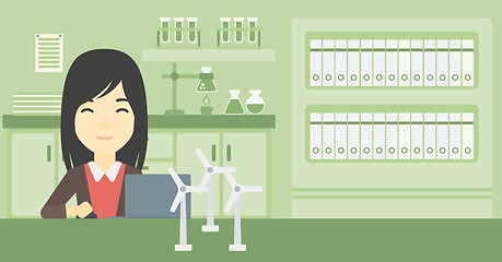 Image showing Woman working with model wind turbines on table.