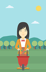 Image showing Woman with plant and wheelbarrow.