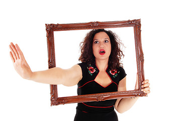 Image showing Woman looking trough picture frame.