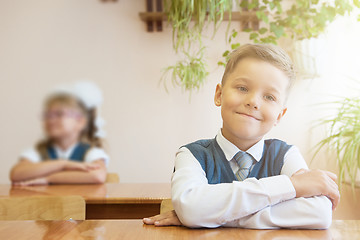 Image showing Happy schoolboy sitting at desk