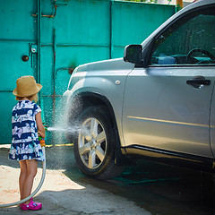 Image showing Little girl helps her parents to wash the car