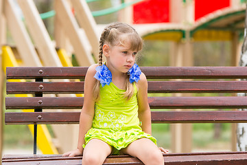 Image showing Offended five year old girl sitting on a bench and crying