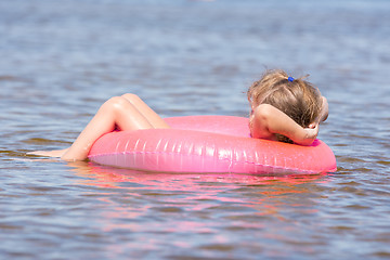 Image showing Five-year girl swims in the river sat on the swimming circle