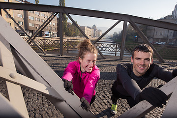 Image showing couple warming up before jogging